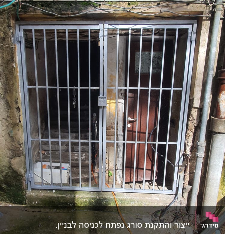 שער מתכת עם סורגים מול כניסה חשוכה